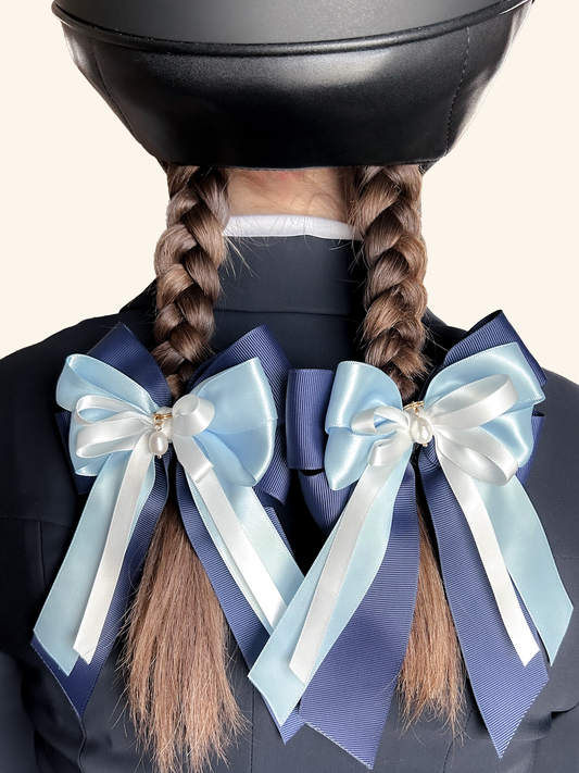 Young equestrian wearing blue and navy horse show bows on braids – Ocean Whisper by Bows & Charms