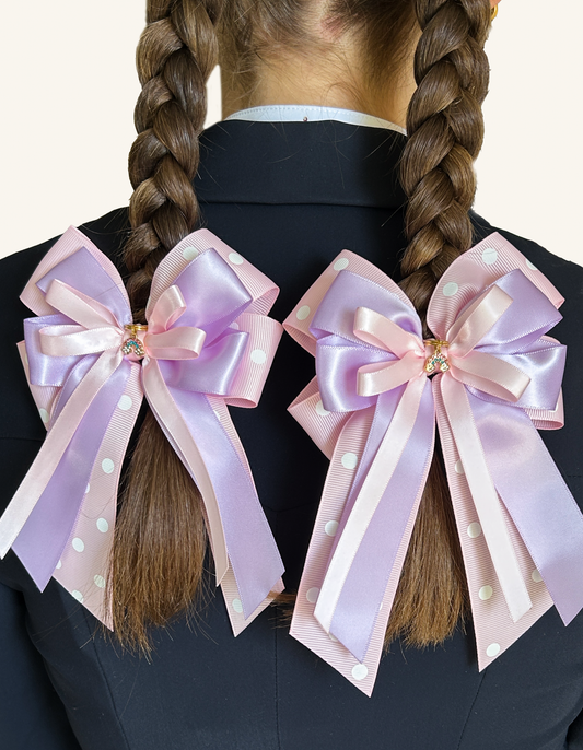 Rainbow Wishes pink and lilac horse show bows worn on a young rider’s braids